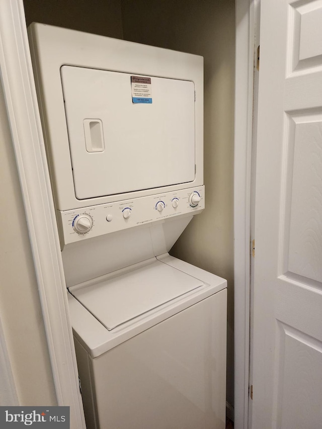 washroom featuring stacked washing maching and dryer