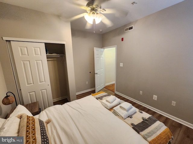 bedroom with dark wood-type flooring, a closet, and ceiling fan