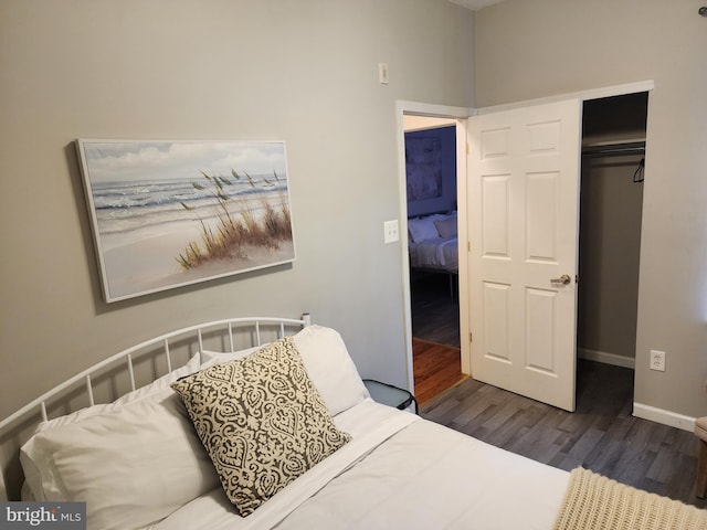 bedroom with dark hardwood / wood-style flooring and a closet