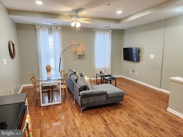 living room with light hardwood / wood-style flooring and ceiling fan