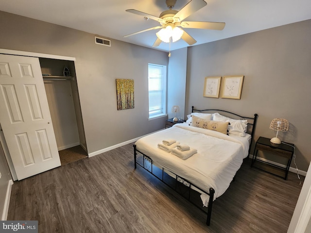 bedroom with dark hardwood / wood-style floors, a closet, and ceiling fan