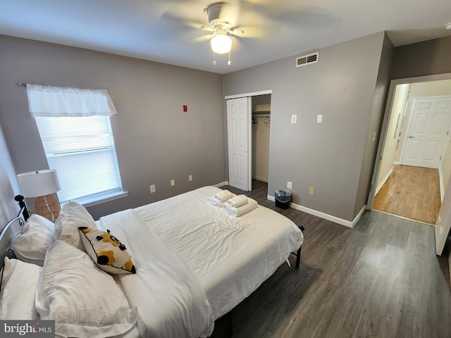 bedroom with dark wood-type flooring, ceiling fan, and a closet