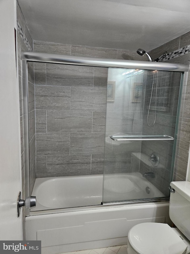 bathroom featuring shower / bath combination with glass door and toilet