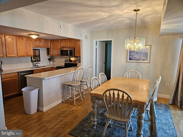 dining space with a chandelier, wood-type flooring, and sink