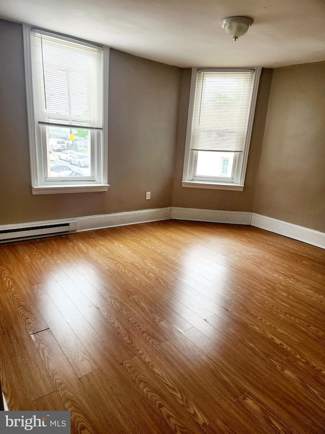 spare room featuring light hardwood / wood-style floors and a baseboard heating unit