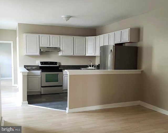 kitchen with appliances with stainless steel finishes, light wood-type flooring, white cabinetry, and sink