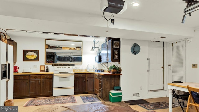 kitchen with sink, white appliances, and dark brown cabinetry