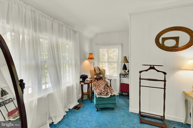 sitting room featuring carpet floors and vaulted ceiling