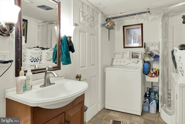 bathroom featuring washer / dryer, a shower, and vanity