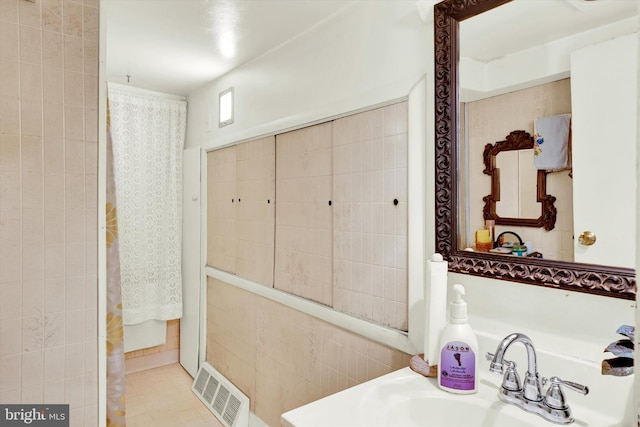 bathroom with sink and tile walls