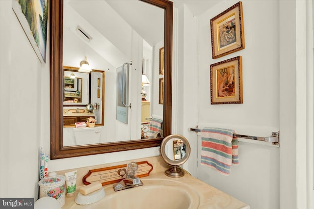 bathroom featuring vaulted ceiling and sink