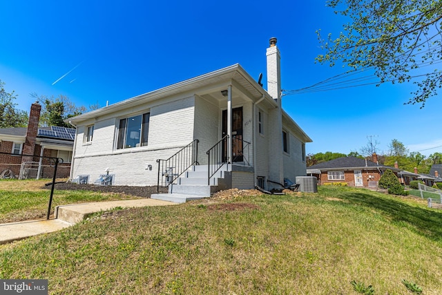 view of front of house featuring central AC unit and a front yard