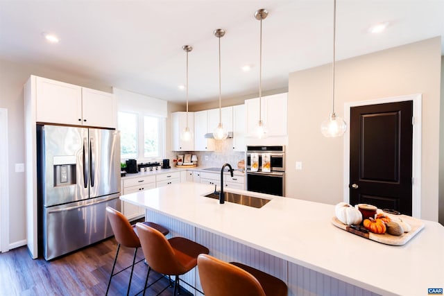 kitchen with decorative light fixtures, stainless steel appliances, and white cabinetry