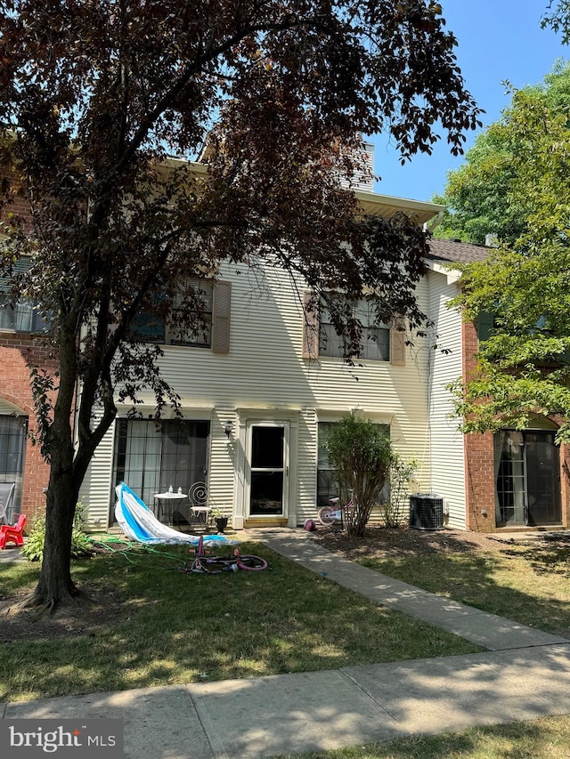 view of front of home featuring a front yard and central AC