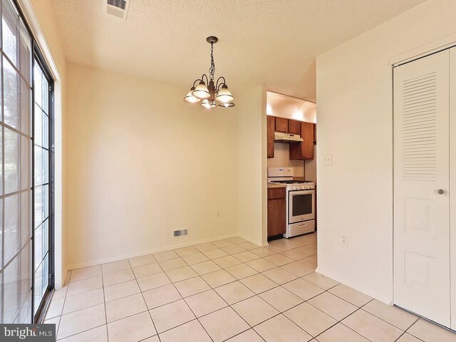 interior space featuring light tile patterned floors, a notable chandelier, and a textured ceiling