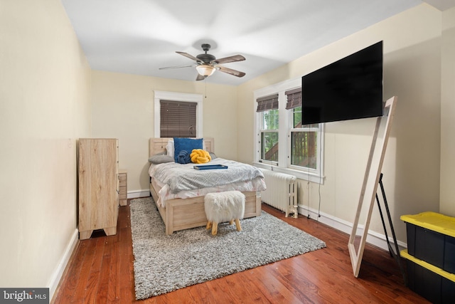 bedroom featuring dark hardwood / wood-style floors, radiator heating unit, and ceiling fan