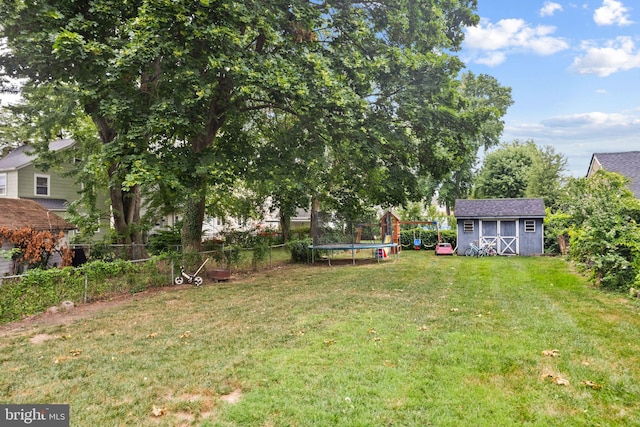 view of yard featuring a trampoline and a storage unit