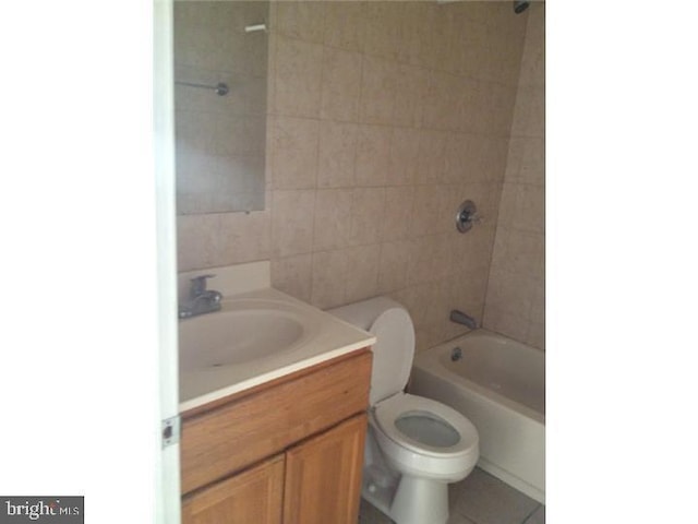 full bathroom featuring vanity, tiled shower / bath combo, and toilet