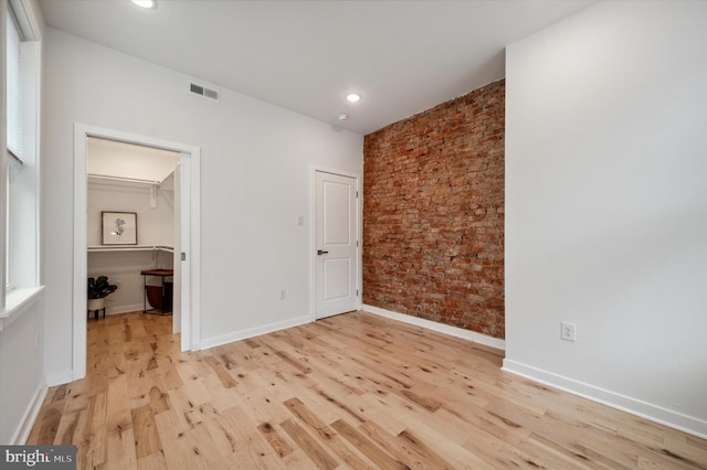 interior space with a spacious closet and light hardwood / wood-style flooring