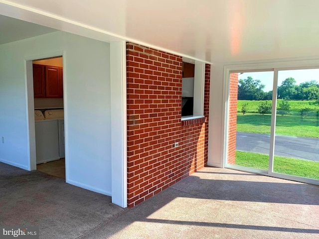 unfurnished sunroom featuring washer and clothes dryer