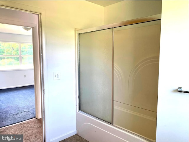 bathroom with shower / bath combination with glass door