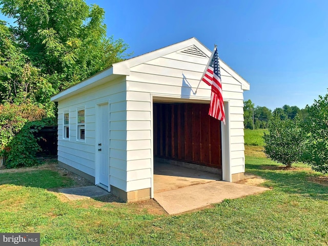 view of outdoor structure with a yard and a garage