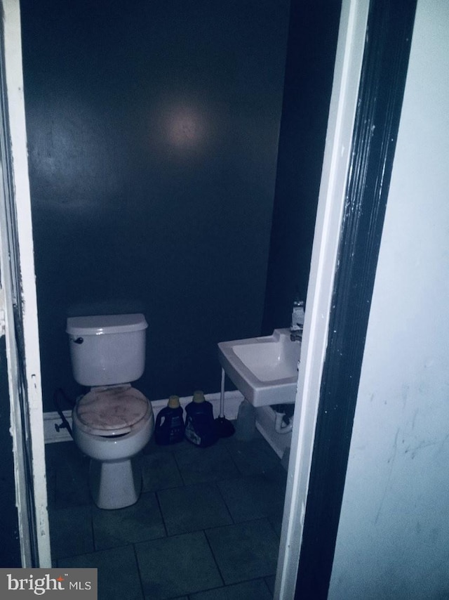 bathroom with sink, toilet, and tile patterned flooring