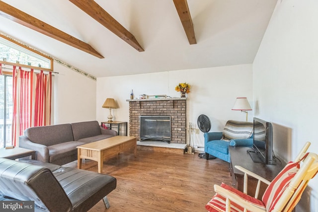 living room featuring hardwood / wood-style flooring, vaulted ceiling with beams, a baseboard heating unit, and a brick fireplace