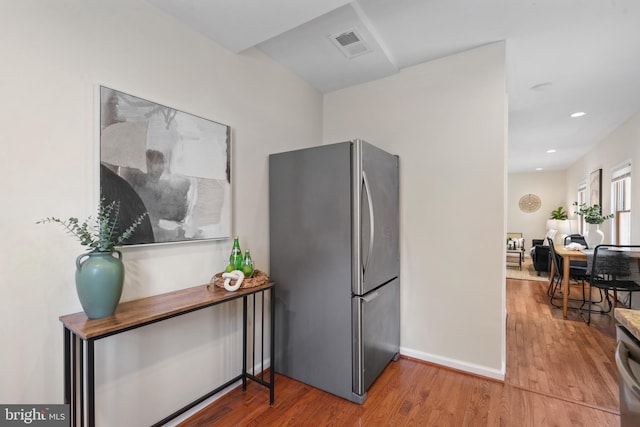 kitchen featuring hardwood / wood-style flooring and stainless steel refrigerator