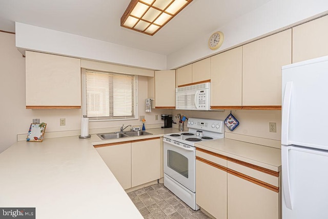 kitchen featuring sink, white appliances, and cream cabinetry