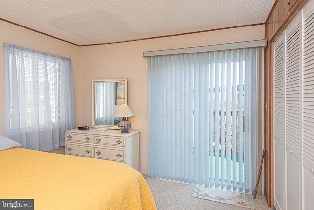 bedroom with light carpet, a textured ceiling, and a closet