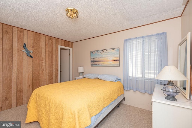 carpeted bedroom with a textured ceiling and wooden walls