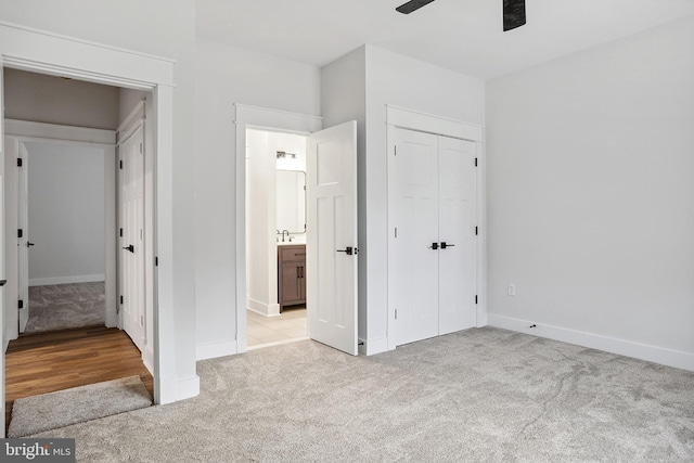 unfurnished bedroom featuring ceiling fan, light colored carpet, sink, and a closet