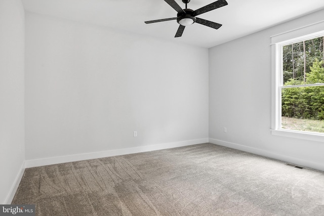 carpeted spare room featuring ceiling fan