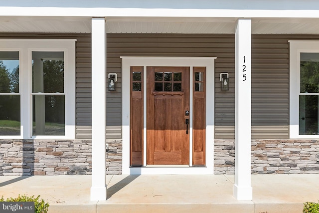 view of exterior entry with covered porch