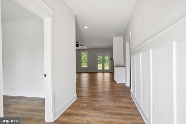 corridor with french doors and hardwood / wood-style flooring