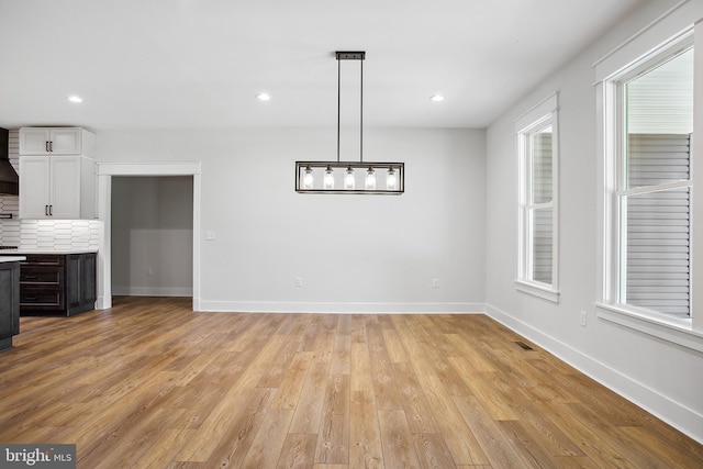 unfurnished dining area with light wood-type flooring