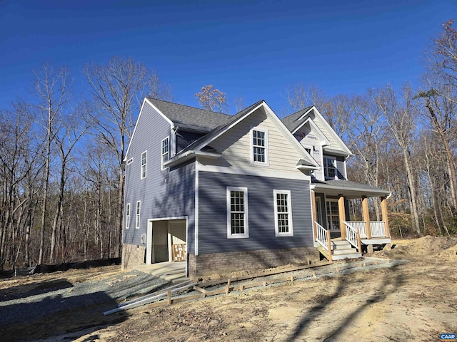 view of home's exterior with a garage and a porch