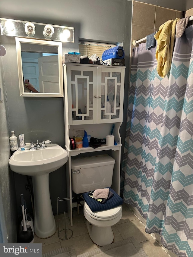 bathroom with walk in shower, tile patterned flooring, and toilet