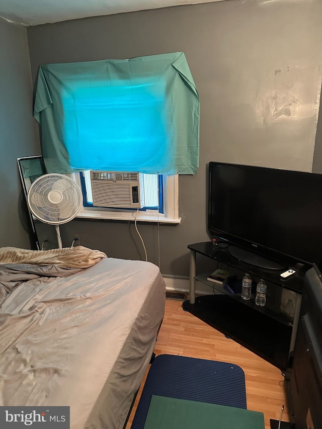 bedroom featuring wood-type flooring and cooling unit