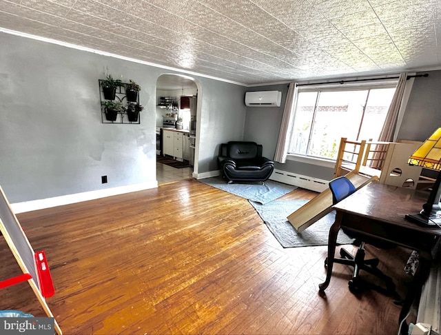 office space with a wall unit AC, ornamental molding, wood-type flooring, and a baseboard radiator