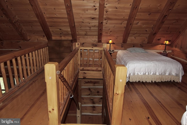 unfurnished bedroom featuring hardwood / wood-style floors, wooden walls, wooden ceiling, and lofted ceiling with beams