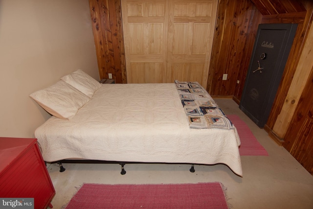 carpeted bedroom featuring wood walls