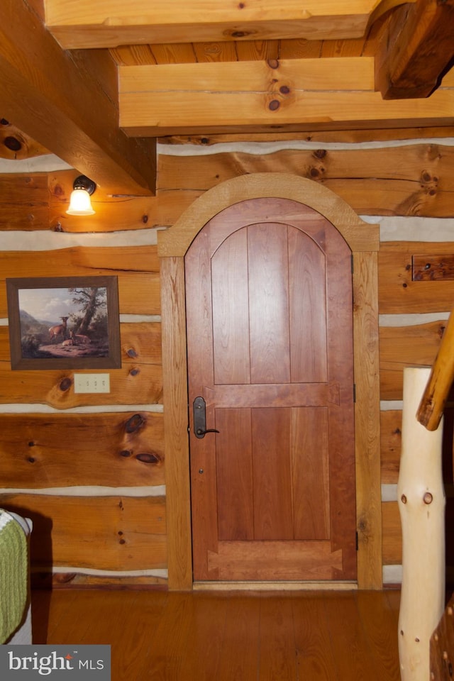 room details featuring hardwood / wood-style flooring, wooden walls, and beam ceiling