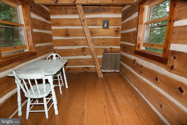 dining space with wood-type flooring and wood walls