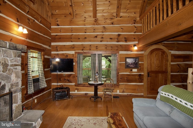 living room featuring hardwood / wood-style floors, wood ceiling, wooden walls, and a stone fireplace