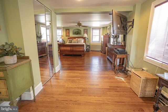 hall with radiator and hardwood / wood-style floors