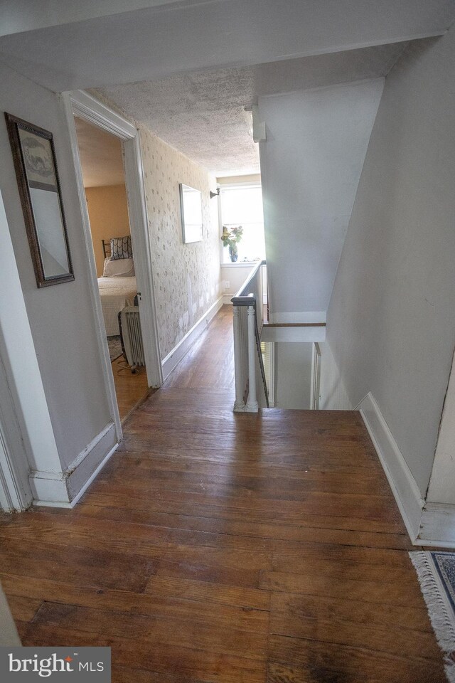 hall featuring dark hardwood / wood-style floors and a textured ceiling