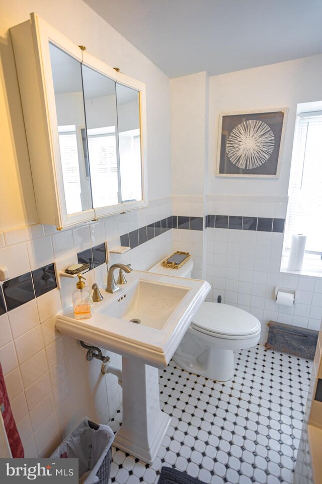 bathroom with tile patterned flooring, tile walls, and toilet