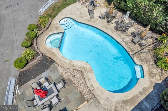 view of swimming pool with an in ground hot tub and a patio